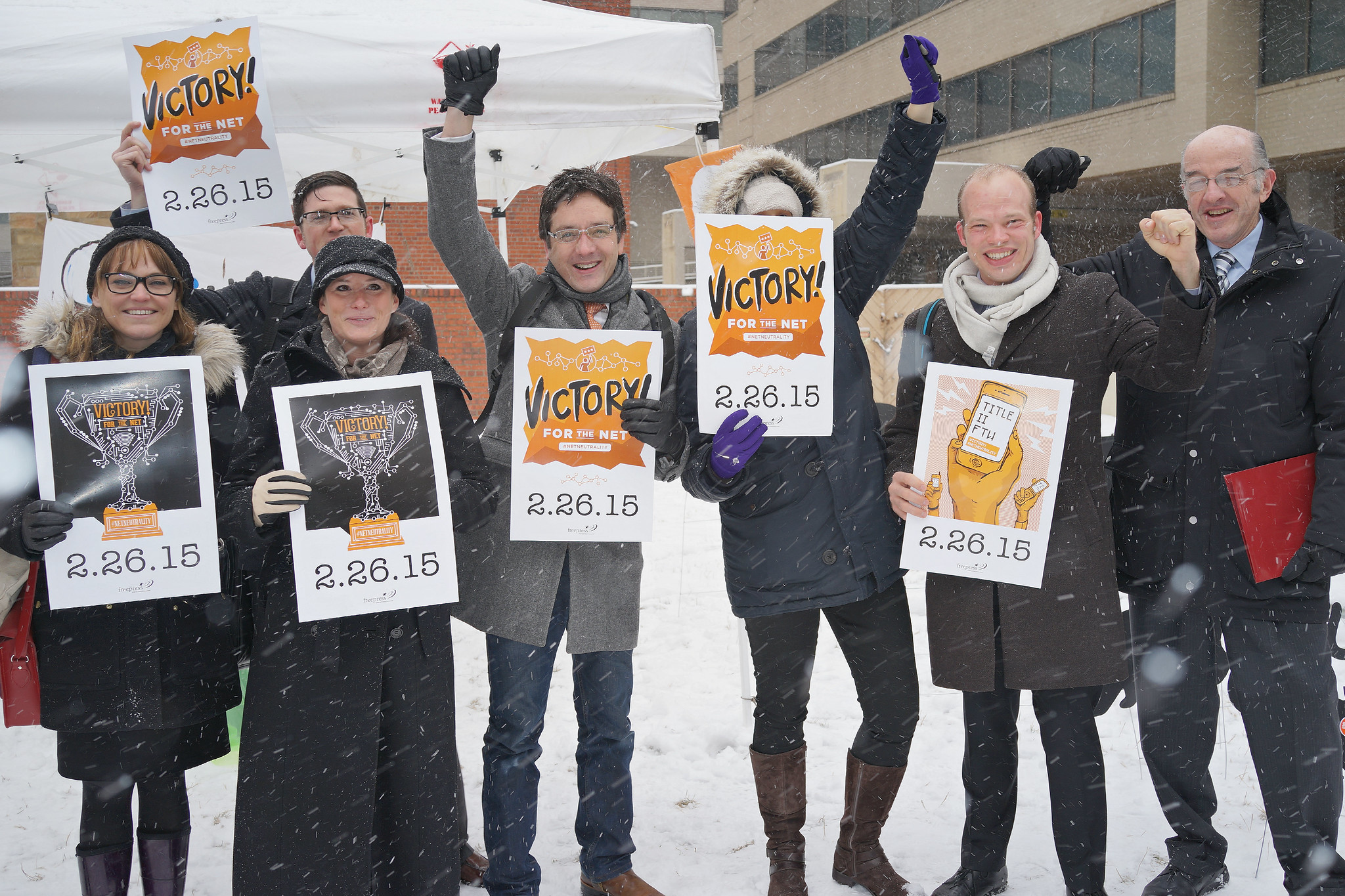 Group of Free Press staff and allies holding victory signs outside the FCC the day the agency voted to adopt real Net Neutrality protections